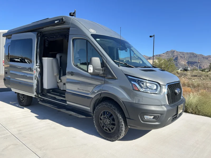 2024 Ford Transit 350 148 High Roof AWD, front three-quarter passenger side with sliding door open and Fiamma awning