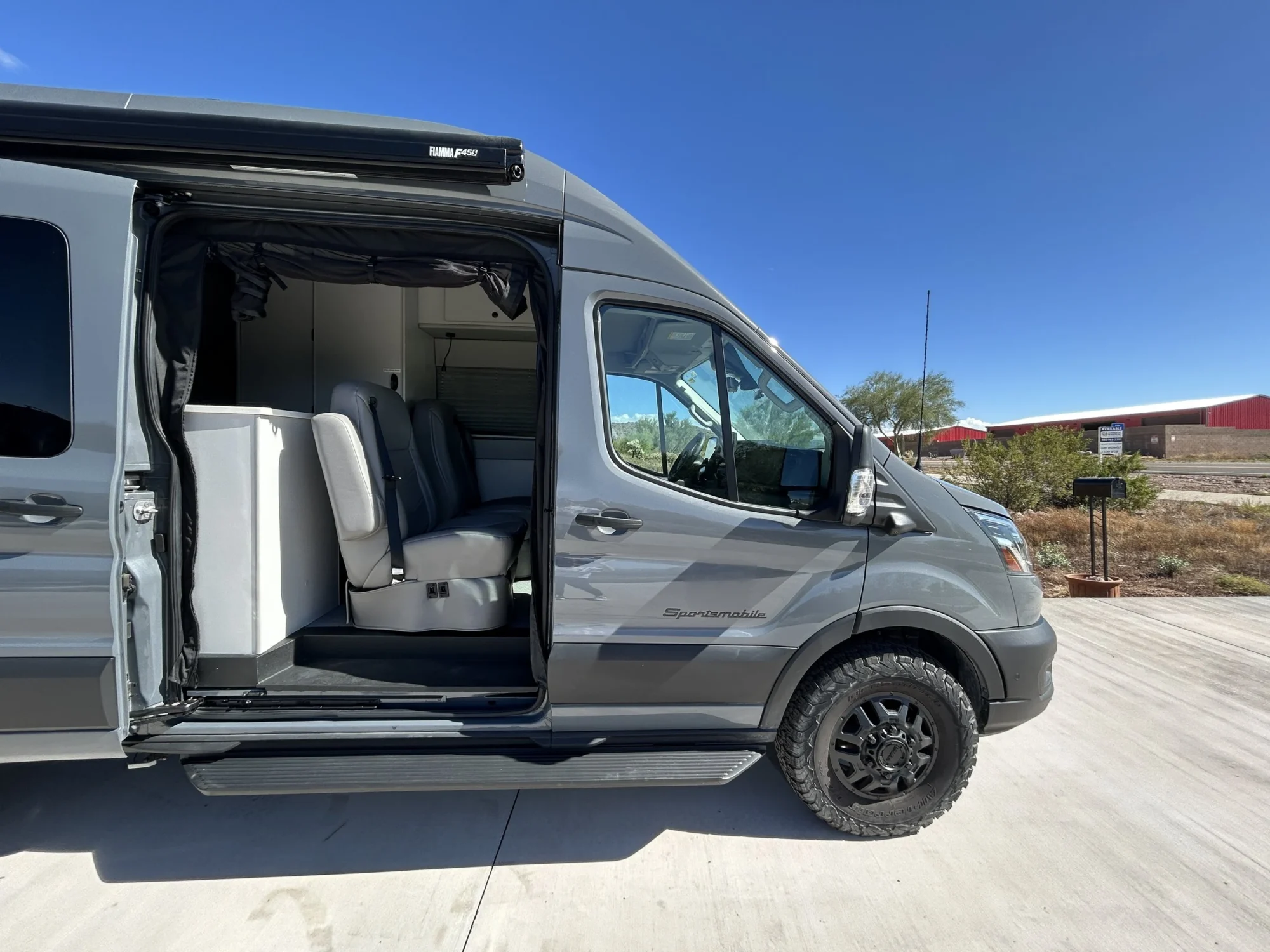 2024 Ford Transit 350 148 High Roof AWD, passenger-side angle showing open sliding door and running board