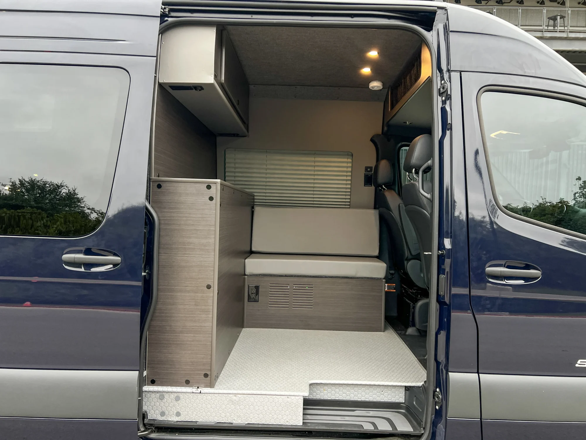 Mercedes Sprinter 2500 144 High Roof AWD Motorcycle Hauler and Front Sitting Area, sliding door view of the ottoman and partition wall