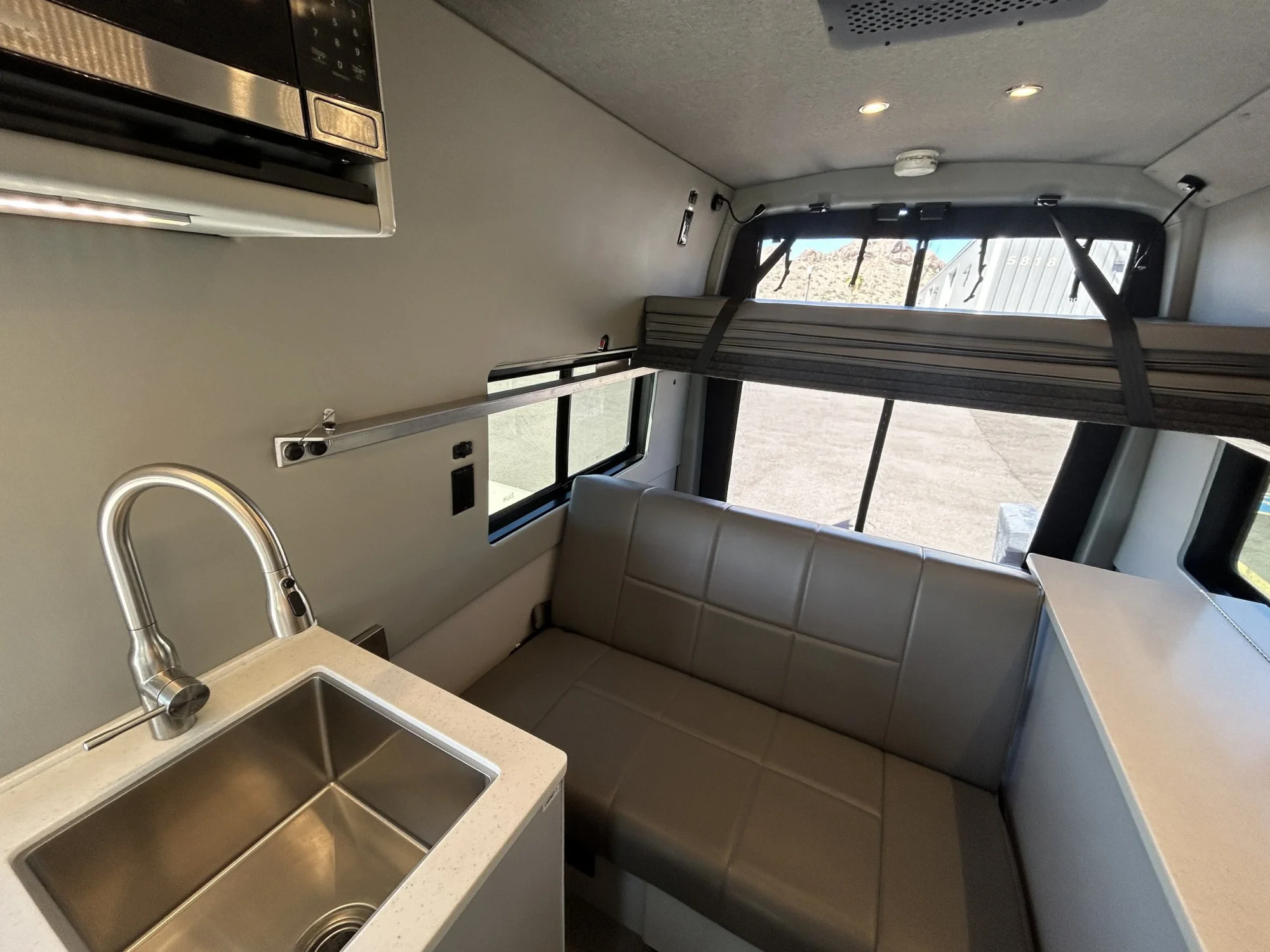 2024 Ford Transit 350 148 High Roof AWD, galley sink, built-in microwave, RB sofa, and upper platform bed