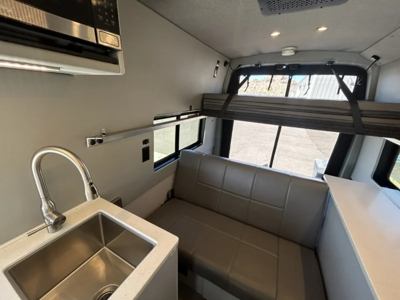 2024 Ford Transit 350 148 High Roof AWD, galley sink, built-in microwave, RB sofa, and upper platform bed