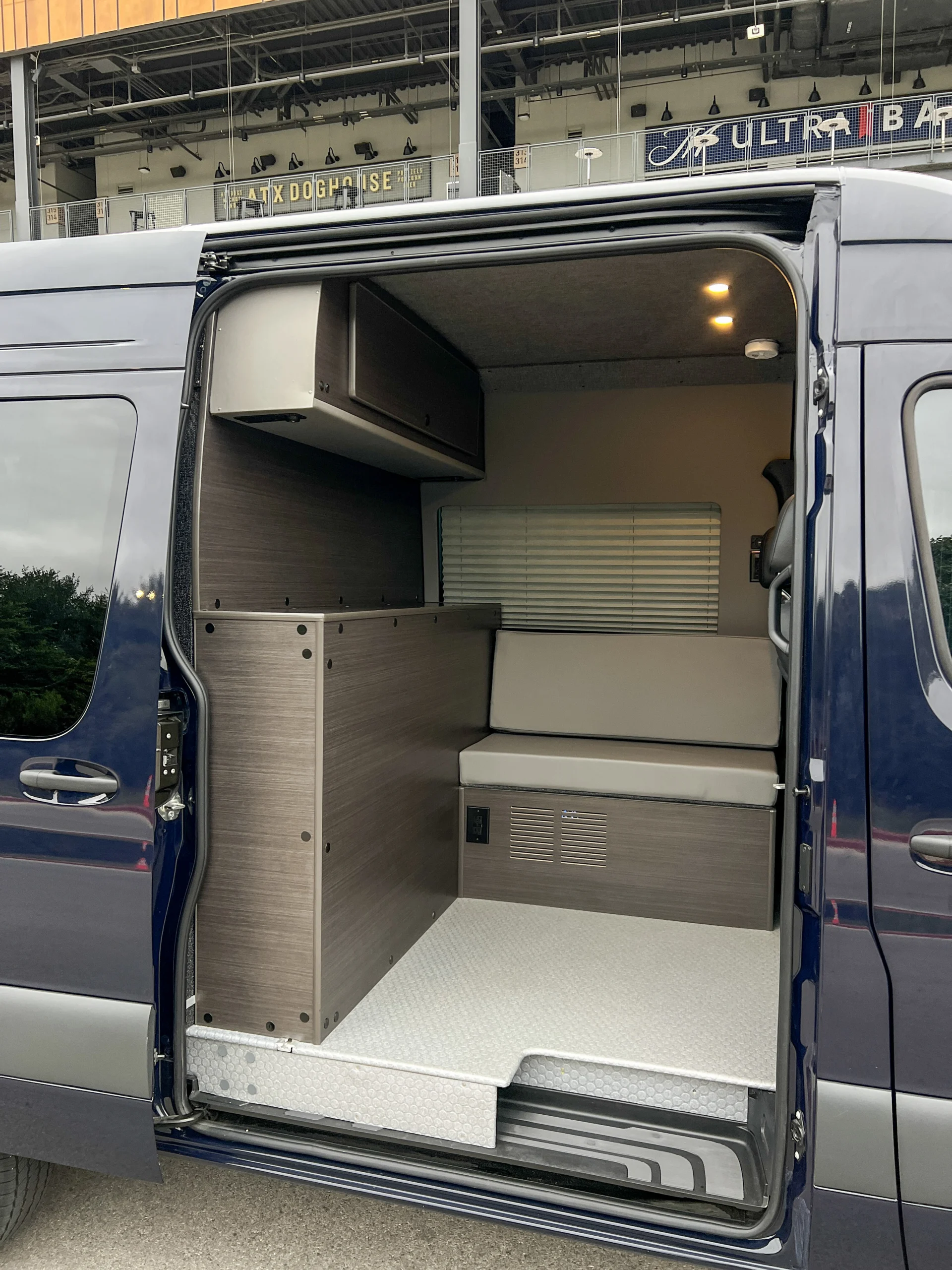 Mercedes Sprinter 2500 144 High Roof AWD Motorcycle Hauler and Front Sitting Area, ottoman and partition wall from the sliding door