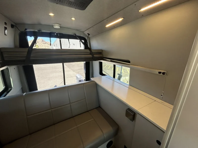 2024 Ford Transit 350 148 High Roof AWD, rear lounge with RB sofa, passenger-side counter, and upper platform bed