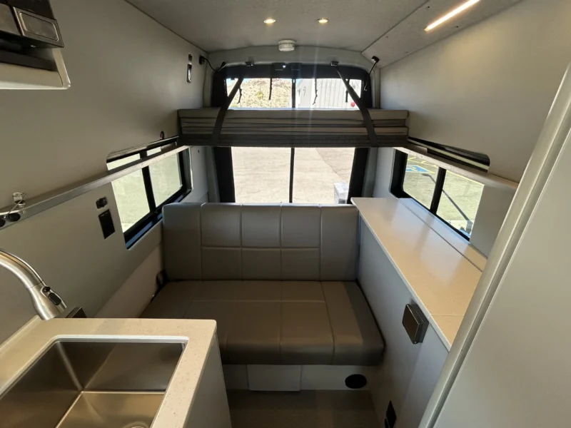 2024 Ford Transit 350 148 High Roof AWD, rear seating area and upper platform bed looking toward rear doors