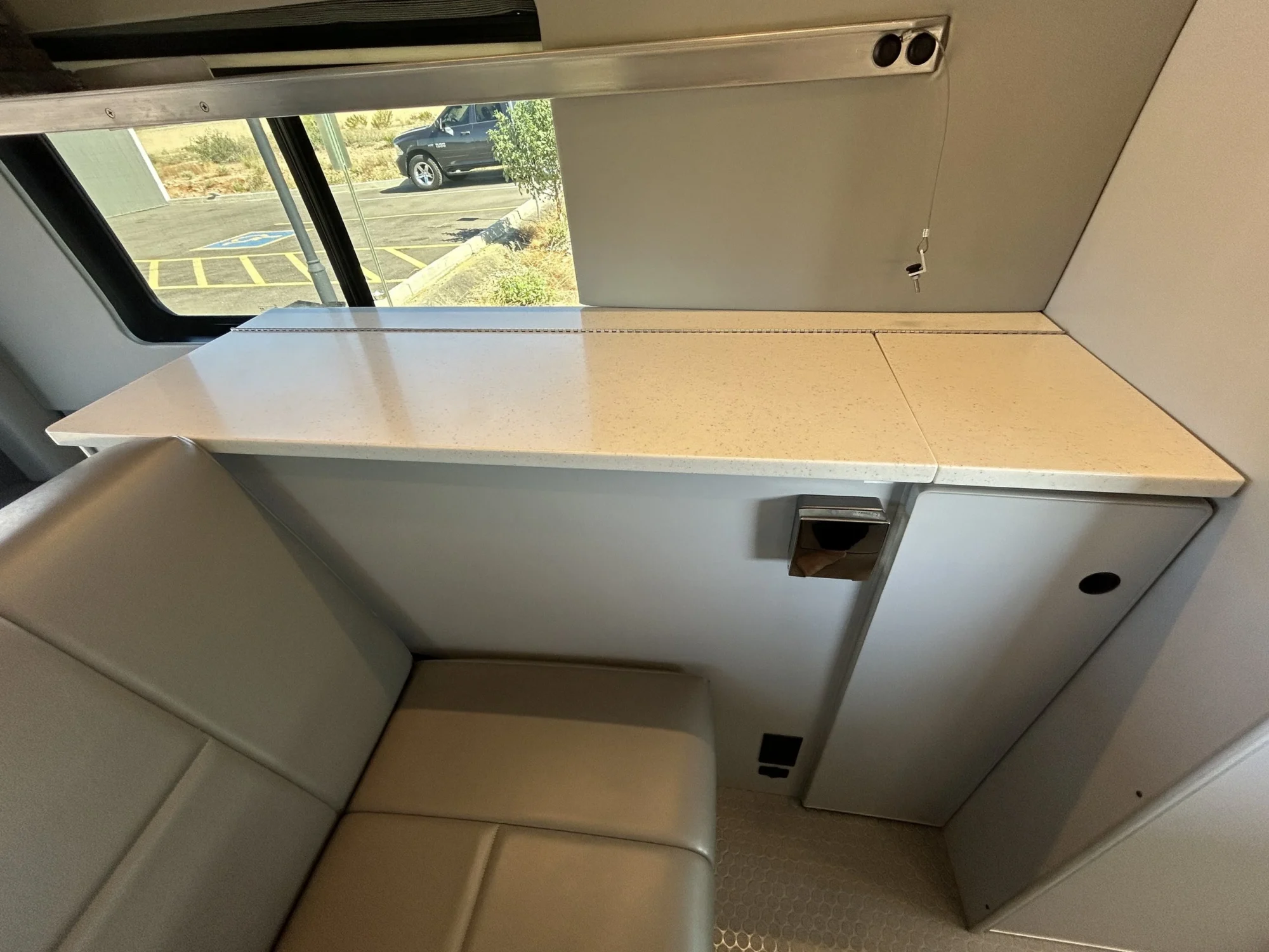 2024 Ford Transit 350 148 High Roof AWD, passenger-side flip-top counter and cabinet storage beside rear sofa