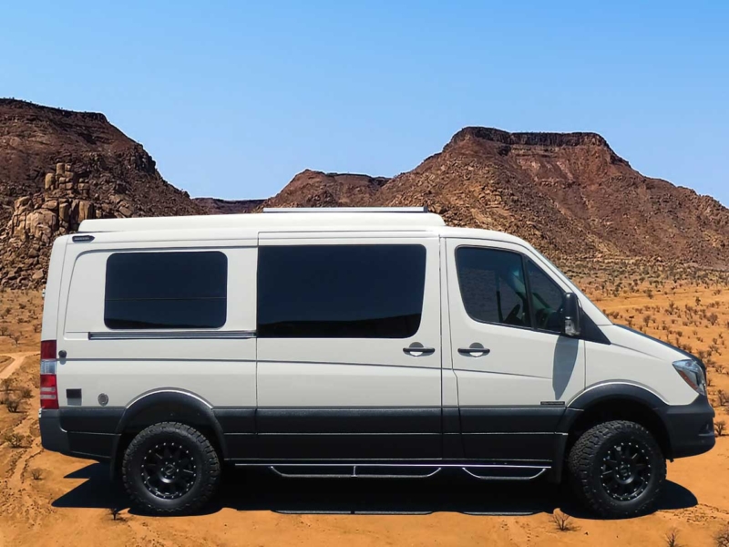 Profile view of a white and black Transit camper conversion van.