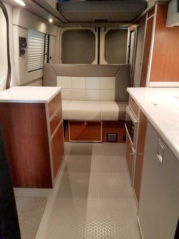 An interior sofa inside a custom Sportsmobile Sprinter RB 150M conversion van.