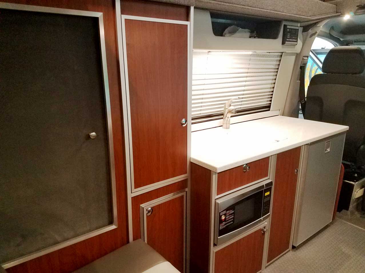 An interior large combination closet inside a custom Sportsmobile Sprinter RB 150M conversion van.