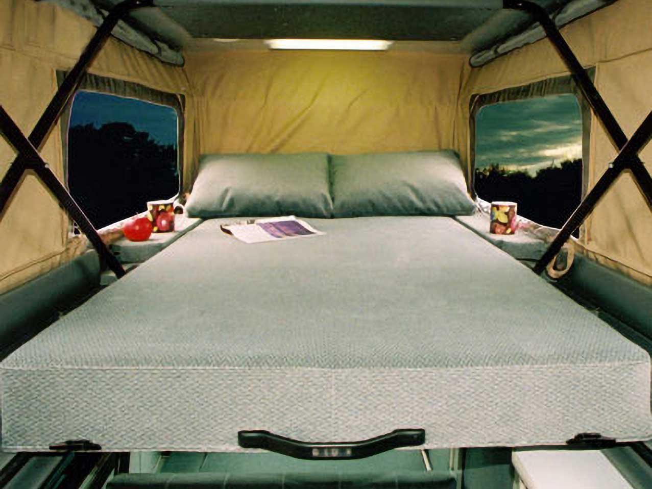 Penthouse bed sleeps 2 inside a custom Sportsmobile Sprinter RB 150M conversion van.