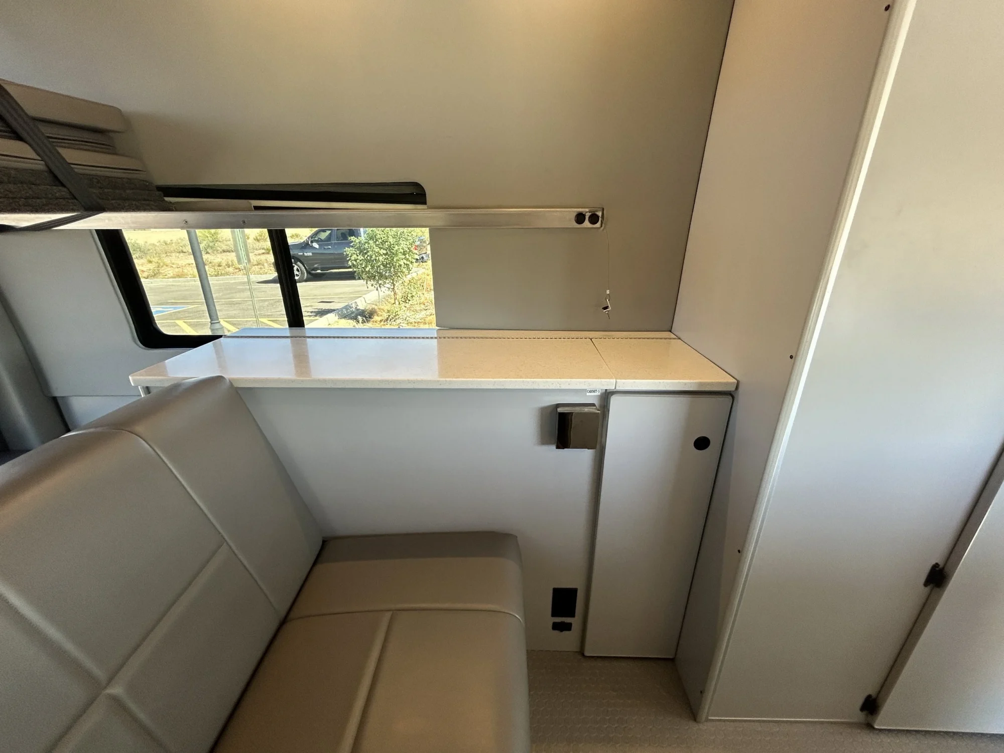 2024 Ford Transit 350 148 High Roof AWD, passenger-side counter, slider window, L-track, and tall rear cabinet