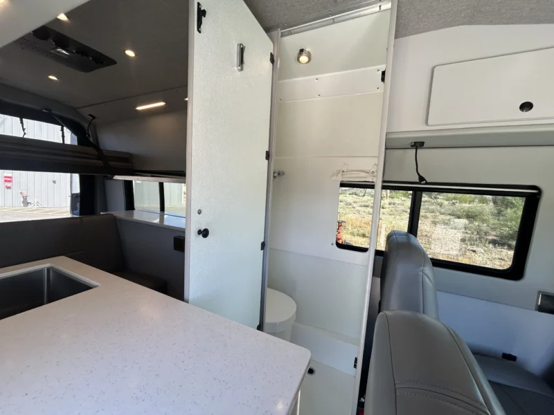 2024 Ford Transit 350 148 High Roof AWD, tall bath compartment interior and passenger-side captain's chairs