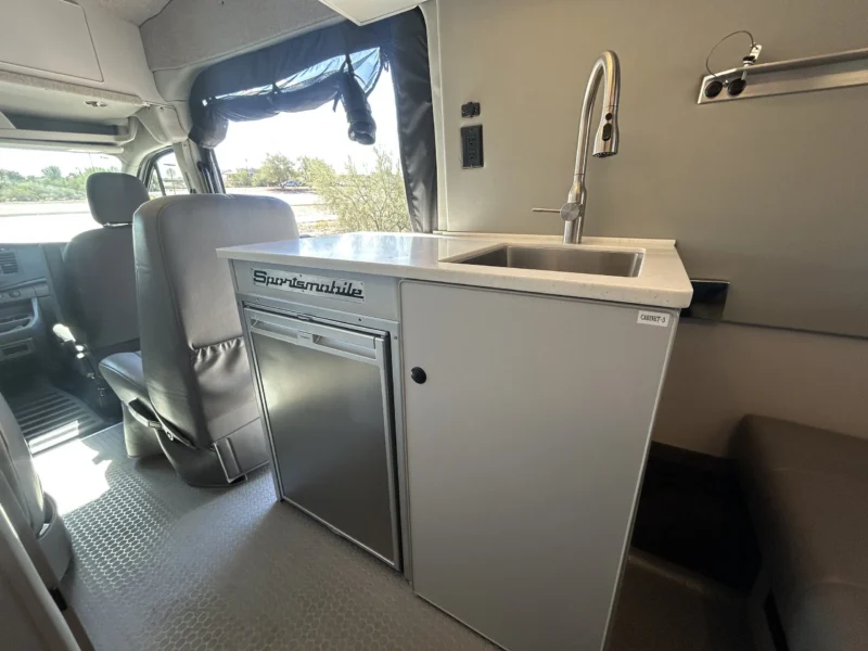 2024 Ford Transit 350 148 High Roof AWD, galley cabinet with stainless sink, gooseneck faucet, and Dometic CRX-110S fridge