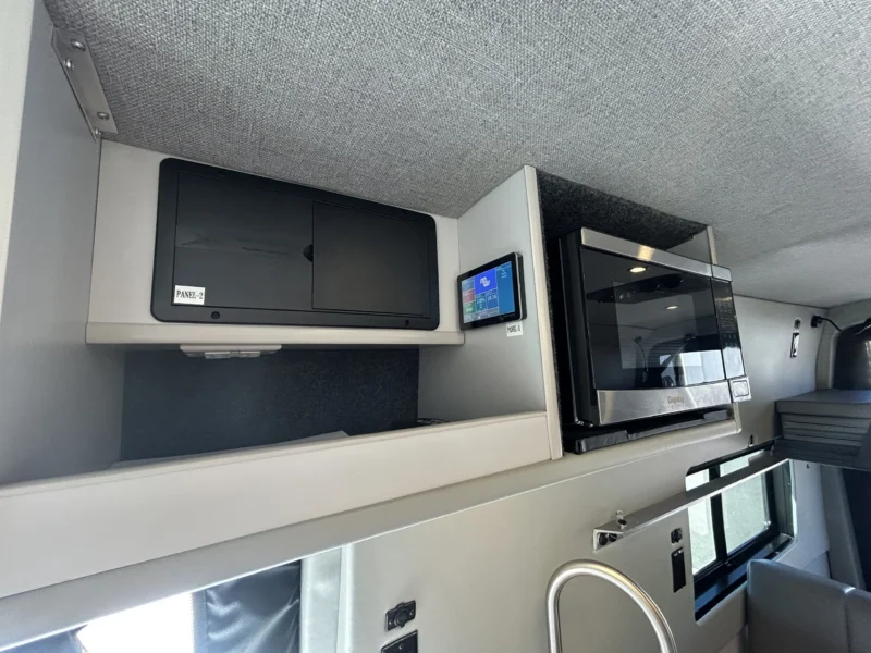 2024 Ford Transit 350 148 High Roof AWD, upper galley cabinet with 110V microwave, Victron GX Touch 50 display, and breaker panel