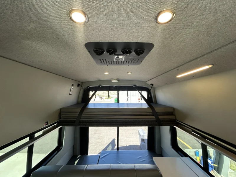 2024 Ford Transit 350 148 High Roof AWD, ceiling view with Nomadic 12V roof-top A/C, LED puck lights, and upper platform bed