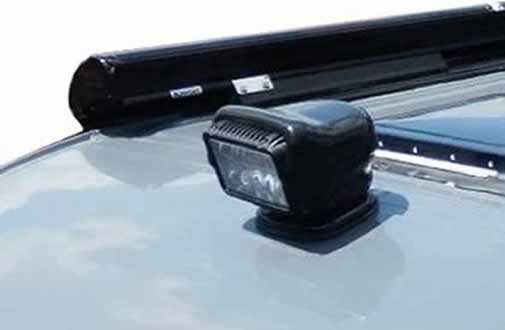 A custom white Sportsmobile conversion van with an upgraded exterior Golight spotlight.