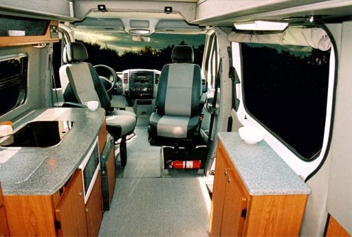 Interior view of Captain seats in positions inside of camper van.