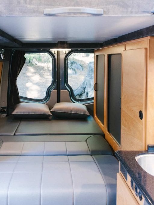 Interior view of Sportsmobile camper van conversion with sofas turned into beds.