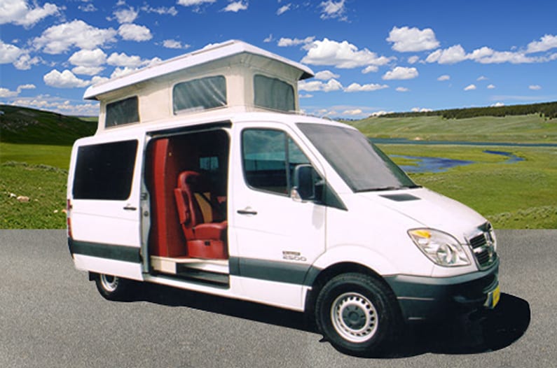 Custom white Sportsmobile Sprinter conversion van with penthouse top extended.