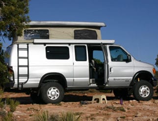 Custom silver camper van with penthouse tope and ladder being rented by Tonta Vehicle Rental.