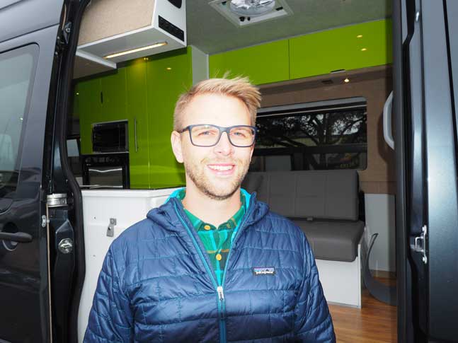 A close up view of Michael standing next to his custom Sportsmobile van conversion van.