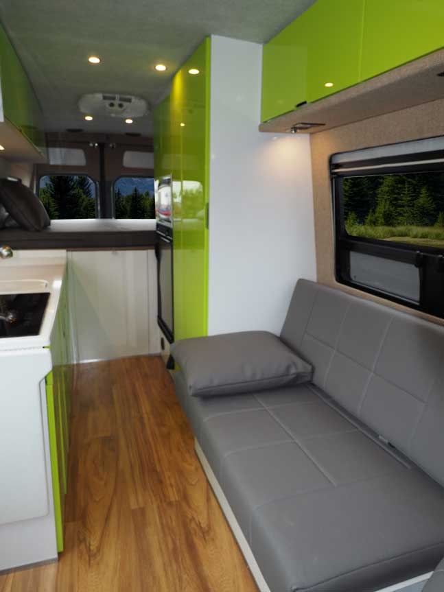 Interior view of a custom Sportsmobile van conversion featuring a Gaucho seats that convert into a bed.