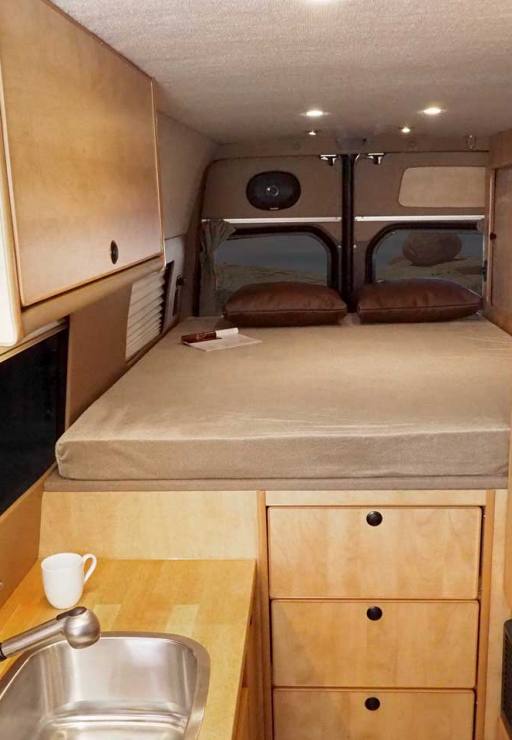 Sprinter interior with maple cabinets and platform bed.