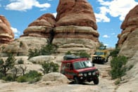 A view of a Red Sportsmobile conversion with the Moab landscape.