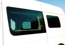 Uplcose view of a white Sportsmobile van conversion with an awning in the rear.