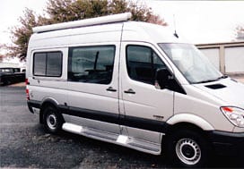 Profile view of a white Sportsmobile van conversion with a tall slider and slider door window.