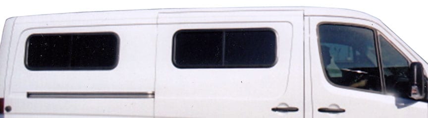 Profile view of a white Sportsmobile van conversion with two large slider windows.