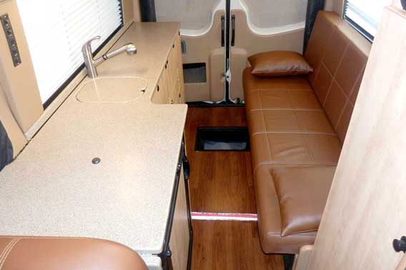 Transit van conversion with upgraded leather upholstery and custom cabinets.