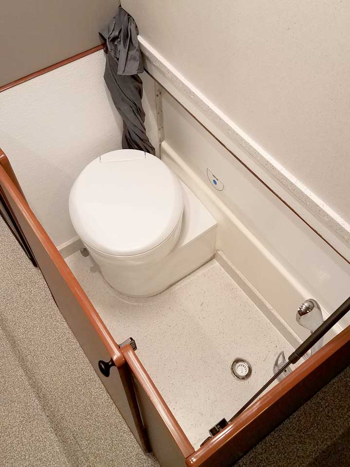 Interior view of toilet compartment next to cabinets in a Sportsmobile conversion van.