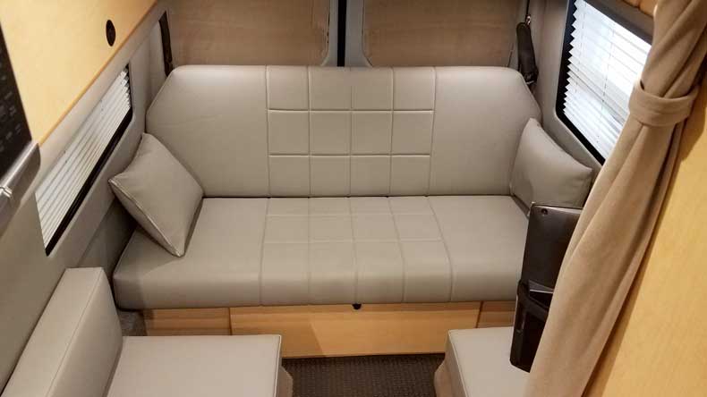Interior view of a custom Sportsmobile conversion van with a leather sofa.