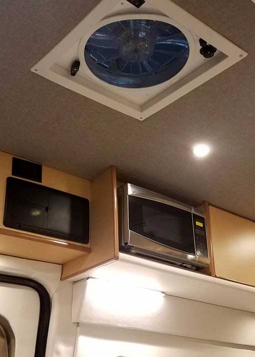 Interior view of a custom Sportsmobile Transit conversion van with upper cabinets.
