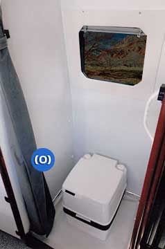Interior view of a shower behind privacy curtains in shower in a Sportsmobile conversion van. 