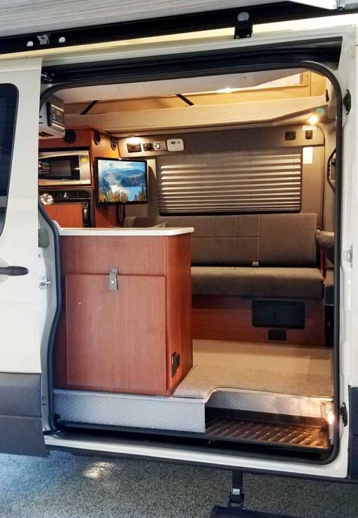 Interior view of a custom Sportsmobile Sprinter van conversion with an open awning.