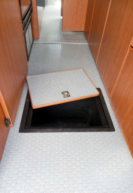 Interior view of a custom Sportsmobile Sprinter van conversion with access to floor compartment.