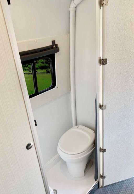 Bath compartment features a toilet, shower, and window.