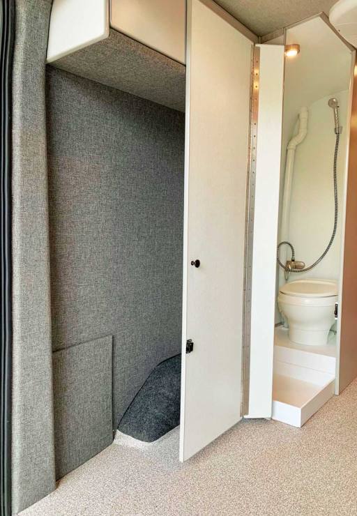 Hidden bath compartment with shower and toilet.