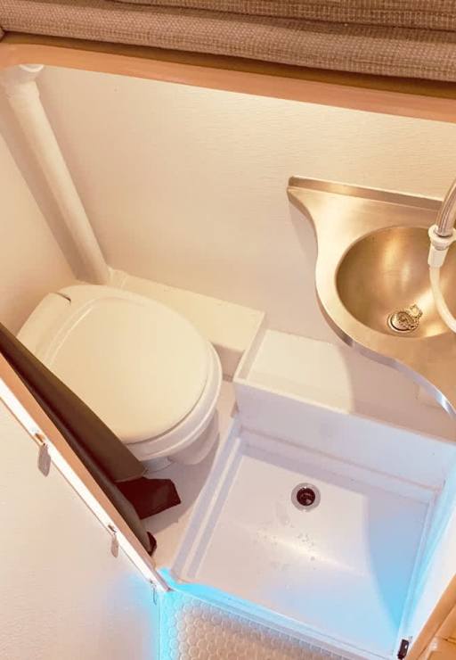 Bath compartment features a toilet, sink, and shower area.