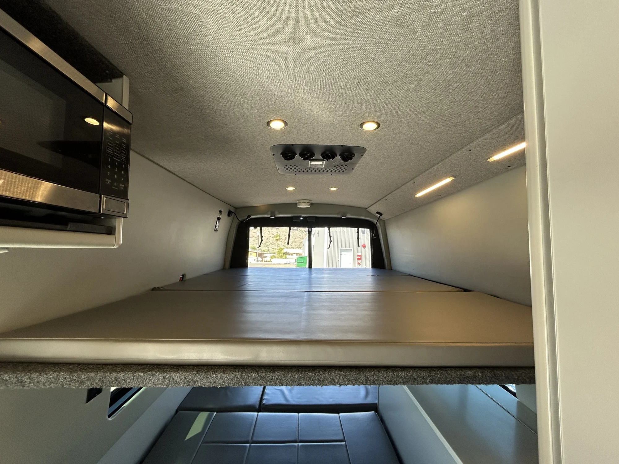 2024 Ford Transit 350 148 High Roof AWD, three-panel upper platform bed above rear lower sleeping area