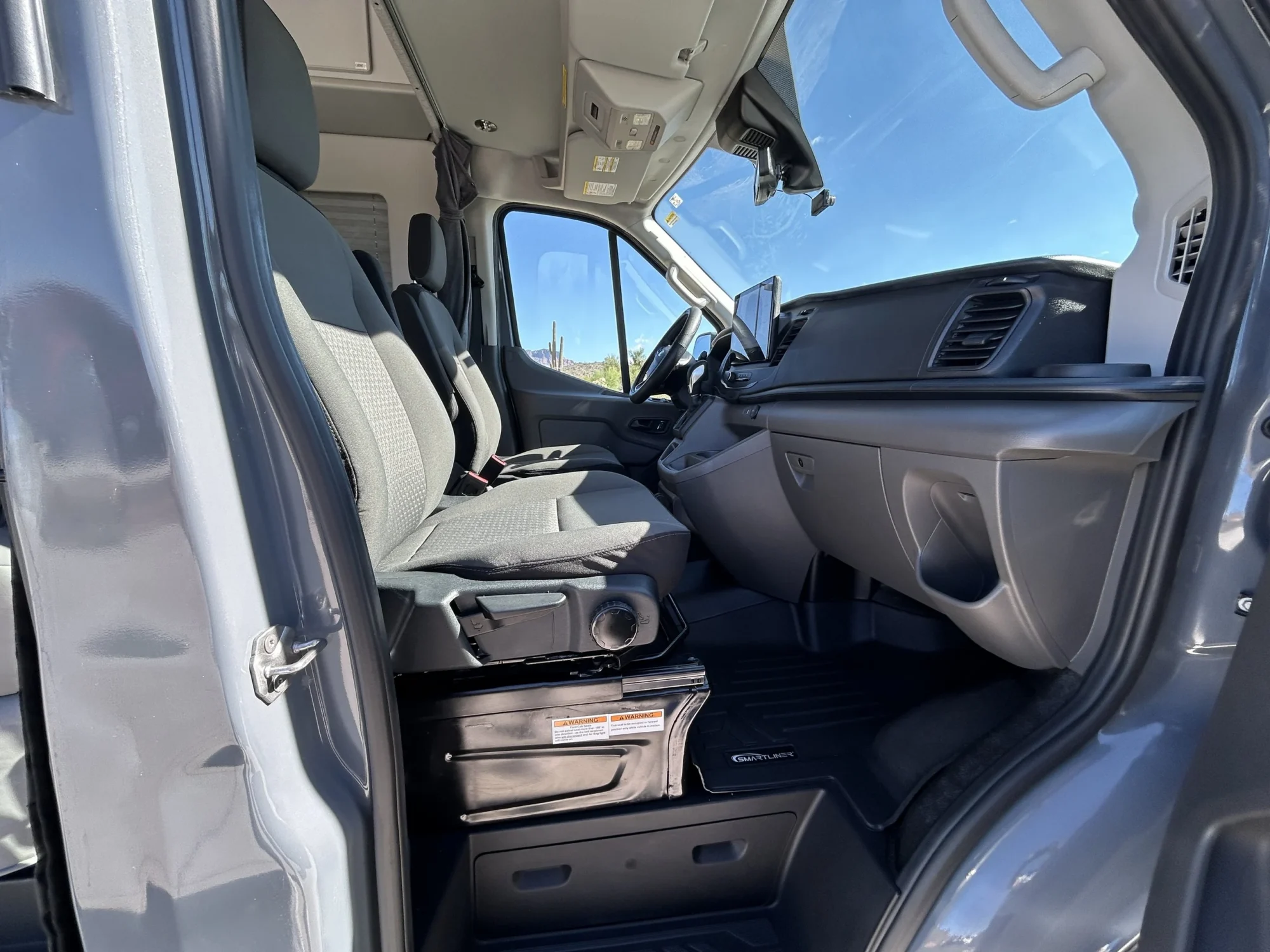 2024 Ford Transit 350 148 High Roof AWD, front cab with Dark Palazzo Gray cloth swivel seats and SYNC 4 touchscreen