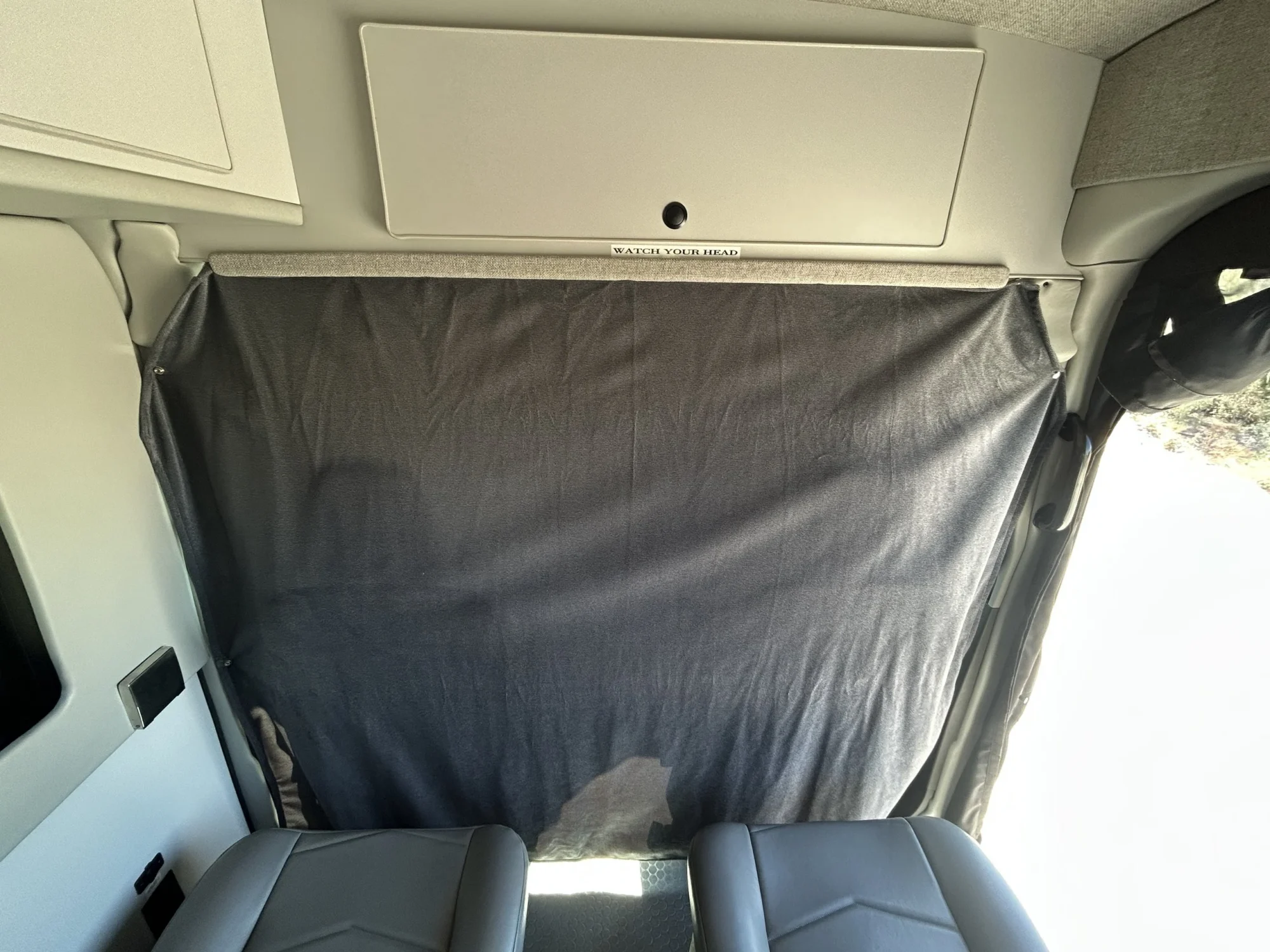 2024 Ford Transit 350 148 High Roof AWD, Winchester Gray cab privacy curtain closed below front overhead cabinet