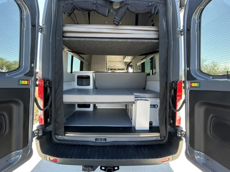 2024 Ford Transit 350 148 High Roof AWD, rear doors open showing upper platform bed, lower mattress, and under-bed garage storage