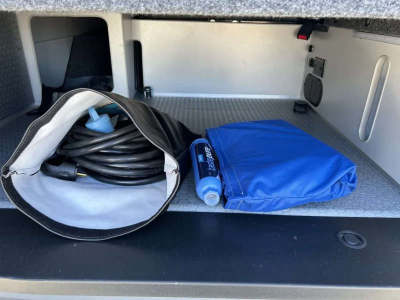 2024 Ford Transit 350 148 High Roof AWD, rear storage compartment with 30A shore power cord and fresh water hoses