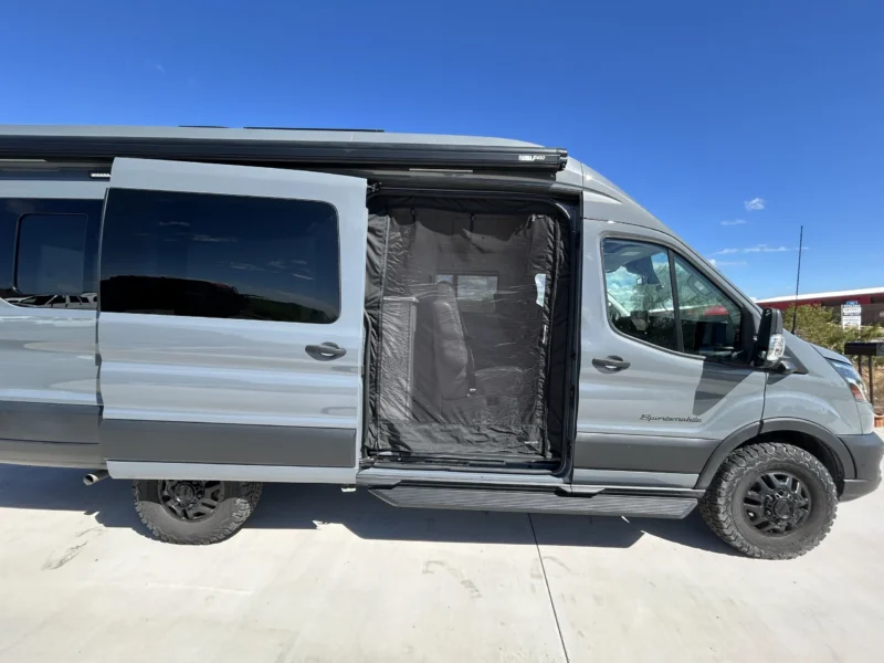 2024 Ford Transit 350 148 High Roof AWD, passenger-side exterior with sliding door bug screen and Fiamma F45s awning