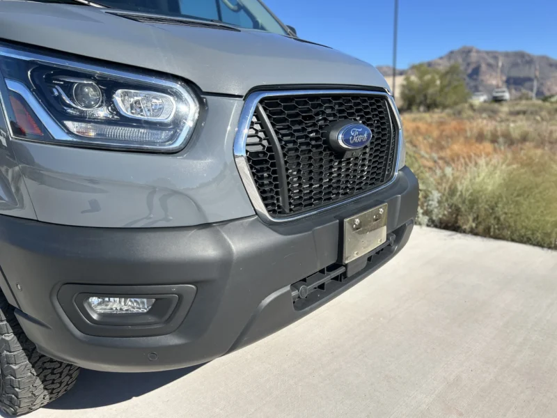 2024 Ford Transit 350 148 High Roof AWD, front passenger-side three-quarter close-up showing grille, HID headlamps, and fog lamps