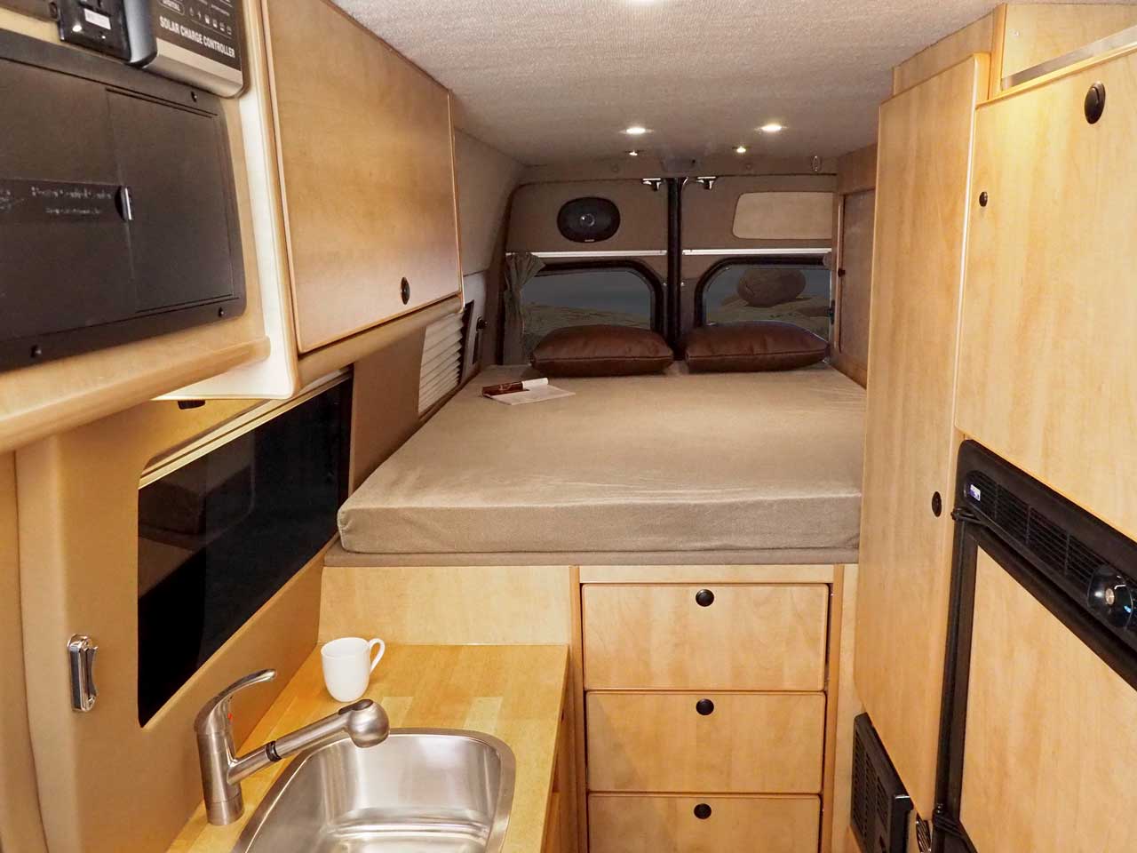 Sprinter interior with maple cabinets and platform bed.
