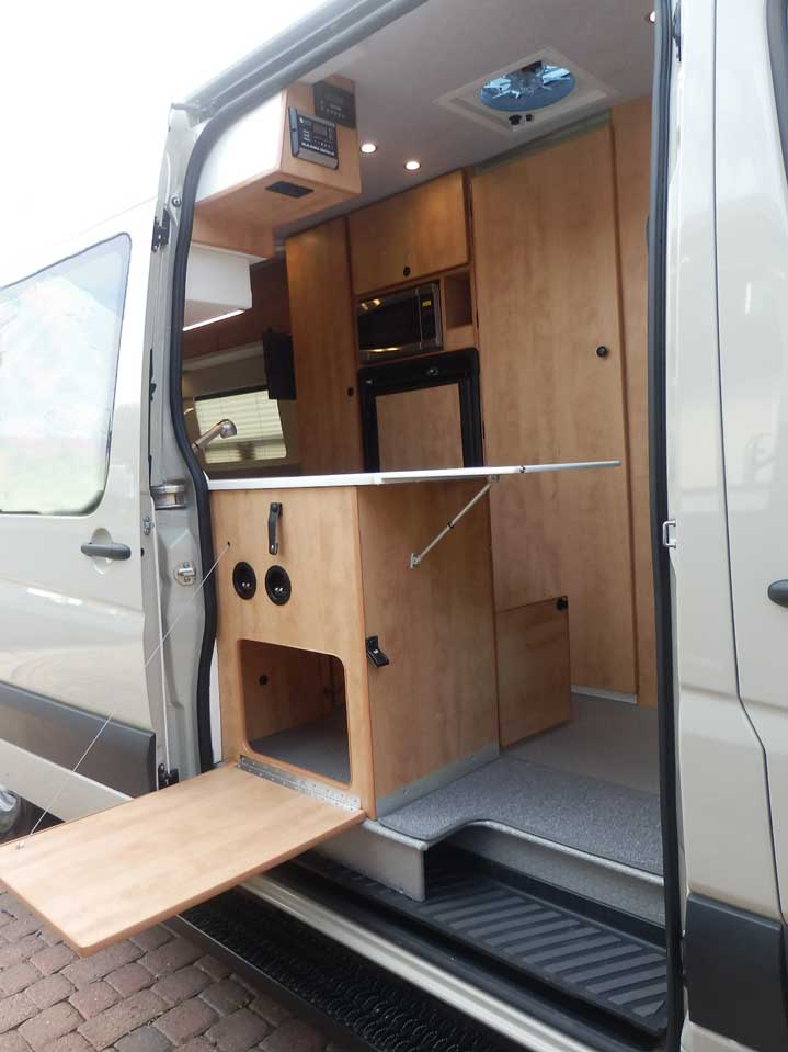 Ford Transit camper conversion featuring a galley with inside and outside access