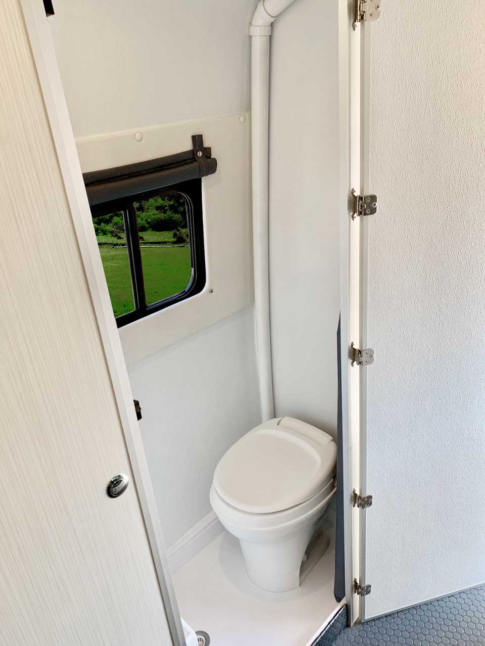 Bath compartment features a toilet, shower, and window.